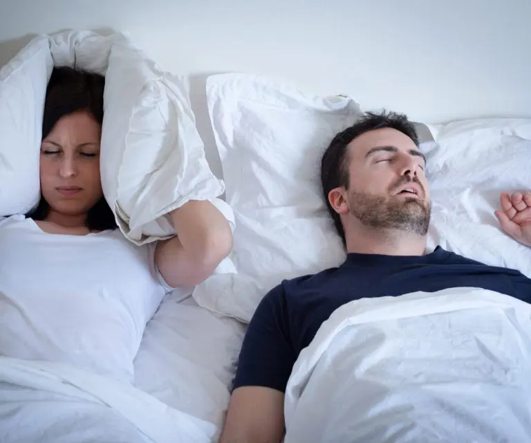 Mann und Frau liegen schlaflos im Bett
