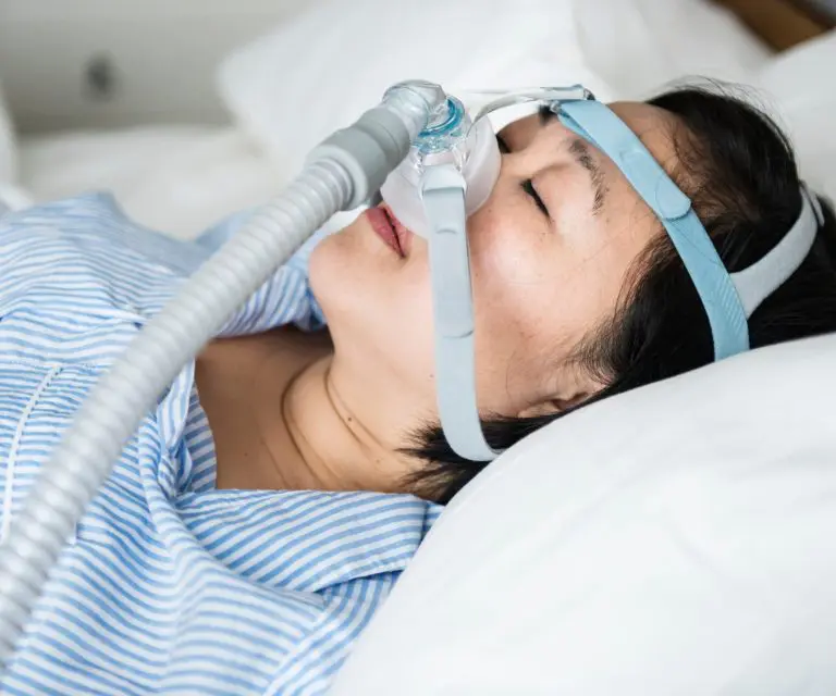 Frau trägt CPAP-Maske