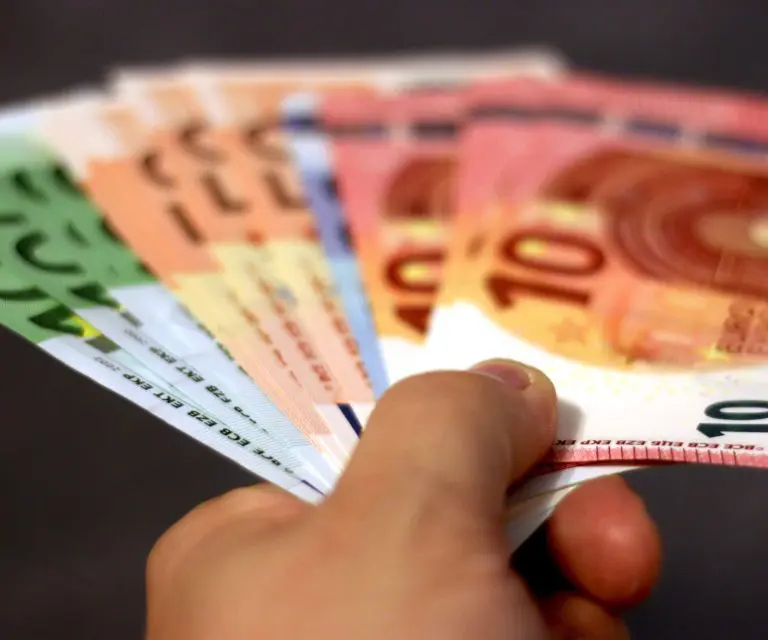 Eine Hand reicht mehrere Euro-Geldscheine.